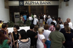 People line up to take money out of an ATM in Greece on June 28.