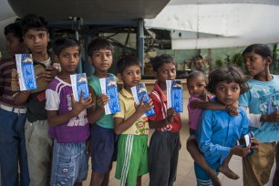 Children with their "boarding passes" wait to get on Gupta's plans.