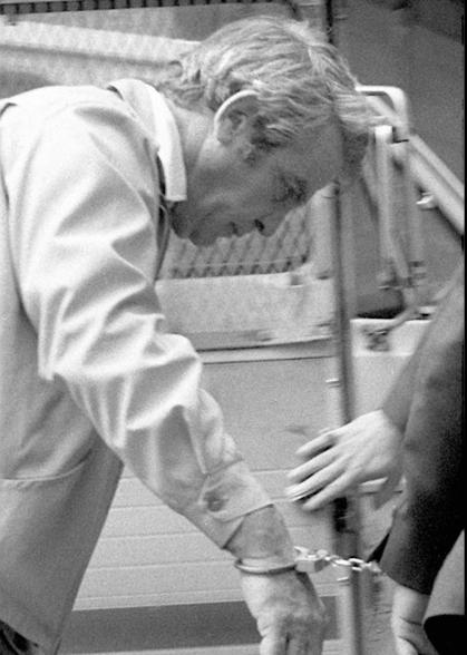 James "Jimmy the Gent" Burke is led handcuffed from a law enforcement vehicle in April 1979.