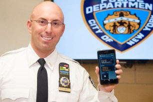 Lt. Bruce Ceparano holds up his department-issued smart phone.