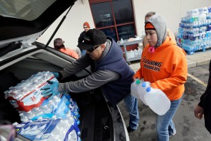 Volunteers load a vehicle with bottled water at Our Lady of Guadalupe Church on Feb. 5. in Flint, Mich.