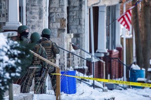 Police stand outside a residence where a gunman opened fire on law enforcement officers serving an arrest warrant in Harrisburg, Pennsylvania.