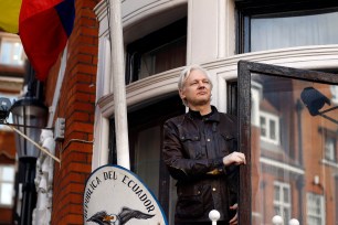 Julian Assange greets supporters outside the Ecuadorian embassy in London.