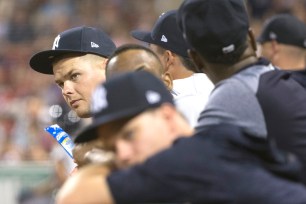 New Yankee Luke Voit (leaning over the dugout) and the rest of the Bombers look on dejectedly during their 15-7 loss to the Red Sox Thursday night in Boston.