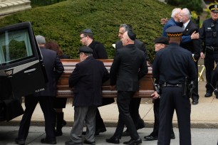 The casket of Irving Younger is led to a hearse outside Rodef Shalom Temple.