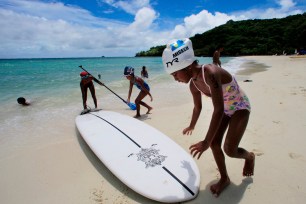 Children play at a resort beach in Ngerkebesang, Palau.