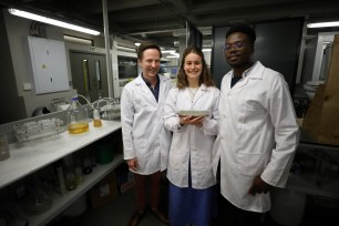 Researchers Dr. Dyllon Randall, Suzanne Lambert and Vukheta Mukhari with a bio-brick made from urine at the University of Cape Town.