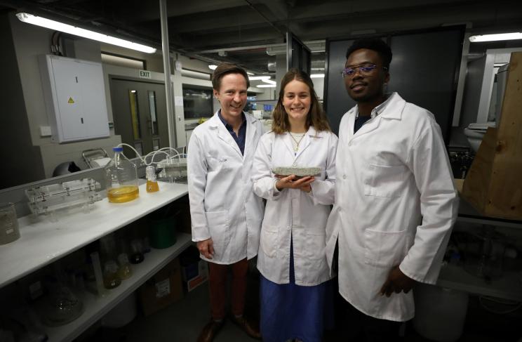 Researchers Dr. Dyllon Randall, Suzanne Lambert and Vukheta Mukhari with a bio-brick made from urine at the University of Cape Town.