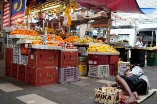 a homeless man sleeps on the floor of a wet market in Kampung Baru, Malaysia