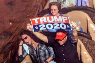 Dion Cini holds a "Trump 2020" sign at Splash Mountain.