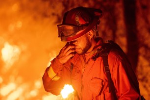 An inmate firefighter pauses during a firing operation as the Carr fire continues to burn in Redding, California on July 27, 2018.