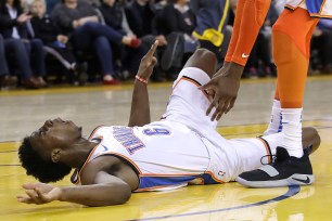 Hamidou Diallo writhes in pain after injuring his left leg in the Thunder's 123-95 win over the Warriors Wednesday night.