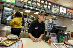 Senior woman working in McDonald's fast food restaurant.