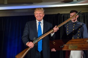 Donald Trump holds up a replica flintlock rifle at the Citadel in South Carolina.
