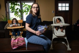 breast milk pumps as she sits with her daughters Lily Pichardo, 3 (left) and her 9-month-old daughter Grace Pichardo (right).