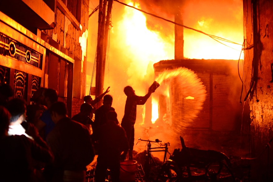 Firefighters and local people help douse a fire in Dhaka, Bangladesh.