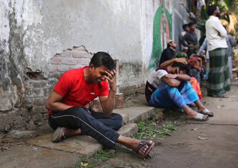 An unidentified Bangladeshi cries by the site of a fire that broke out late Wednesday in closely set buildings in Dhaka, Bangladesh.