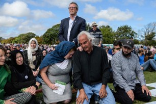 Mourners take part in a two minute silences for the mosque massacre victims in a park near the Al Noor mosque in Christchurch.