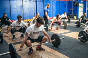 People lifting weights in a Crossfit class.