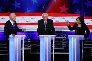 Sen. Kamala Harris and former Vice President Joe Biden speak as Sen. Bernie Sanders looks on during the second night of the first Democratic presidential debate.