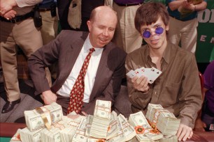 Stu Ungar (right) shows his winning hand at the 1997 World Series of Poker, as host Jack Binion, then head of Binion's Horseshoe, presents him with his prize pot.