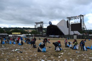 Litter pickers remove rubbish at Glastonbury Festival of Music and Performing Arts.
