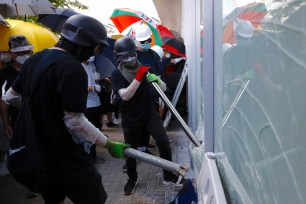 Protesters try to break the glass walls of the Legislative Council in Hong Kong.