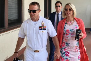 Navy Special Operations Chief Edward Gallagher, left, walks with his wife, Andrea Gallagher as they arrive to military court on Naval Base San Diego
