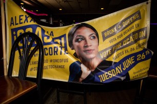 A banner for Alexandria Ocasio-Cortez hangs across chairs at her victory party in June 2018