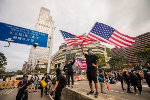 demonstrators wave the American flag