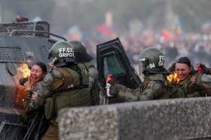 Police try to put out fire of two policewomen who were caught by a molotov bomb