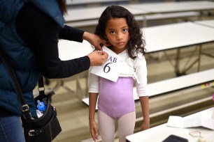 Six-year-old ballet dancer Charlotte Nebres prepares for auditioning as boys and girls ages 6 to 7 try out for The School of American Ballet Winter Term at the P.S. 124 Yung Wing school in New York's Chinatown on April 16, 2015. The School of American Ballet was established in 1934 and is one of the premier ballet academies in the United States. AFP PHOTO / TIMOTHY A. CLARY (Photo credit should read TIMOTHY A. CLARY/AFP via Getty Images)