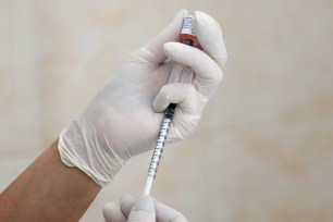 A nurse fills a syringe with a vaccine before administering an injection at a children's clinic in the Ukraine.