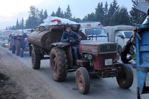 A man pulls a tanker trailer as civilians flee a Syrian military offensive in Idlib province on the main road near Hazano, Syria.