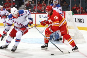 Adam Fox, who had three assists, battles Tobias Rieder for the puck during the Rangers' 4-3 loss to the Flames on Thursday night.