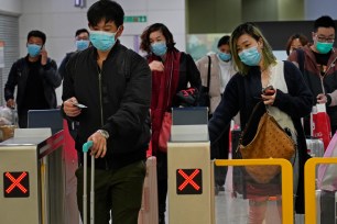 Passengers wear protective face masks arrive at the high speed train station in Hong Kong.