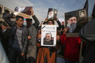 Iranians hold posters of Iran's supreme leader Ayatollah Ali Khamenai and slain commander Qassim Soleimani during a demonstration in Tehran.