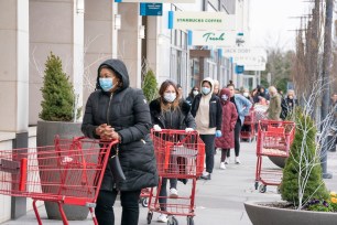 People wait in line with masks and gloves practicing social distancing at Trader Joe's.