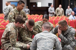 Airmen comfort each other during a memorial service for a colleague who committed suicide, Incirlik Air Base, Turkey.