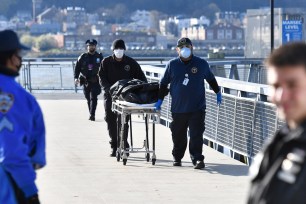 Medical examiners take the body away from 125th and Marginal street, West Harlem Piers today.