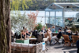 People sit at an outdoor restaurant in Stockholm on Sunday.