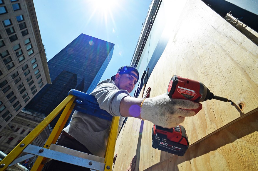 The crew from RSM Facility Service removes protective plywood at the Tissot watch store on 5th Ave on June 9, 2020.