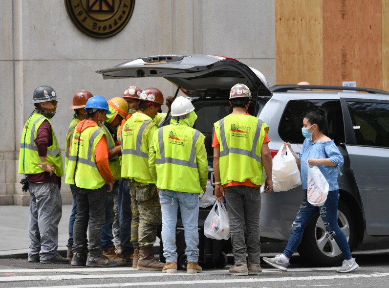 Construction workers take lunch break on the corner of Broadway and Fulton street in lower Manhattan on June 11, 2020.