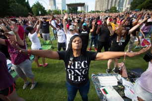 A woman prays during an event hosted by OneRace Movement at Atlanta’s Centennial Olympic Park to commemorate Juneteenth, the date of the emancipation of enslaved African Americans in the U.S., on Friday, June 19, 2020.