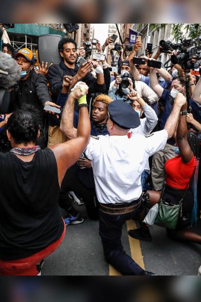 Chief of Department of the New York City Police, Terence Monahan takes a knee with protesters on June 1.