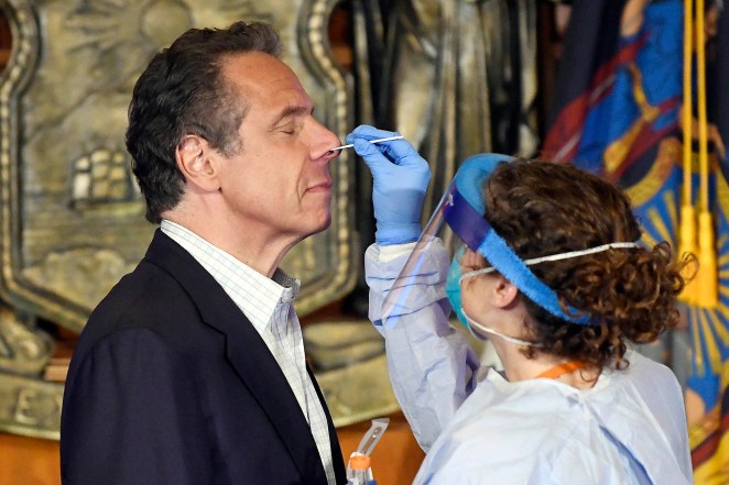 Gov. Andrew Cuomo takes a coronavirus test during a news conference on May 17.