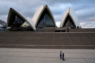 Police officers patrol near the Sydney Opera House following coronavirus restrictions in Sydney, Australia.