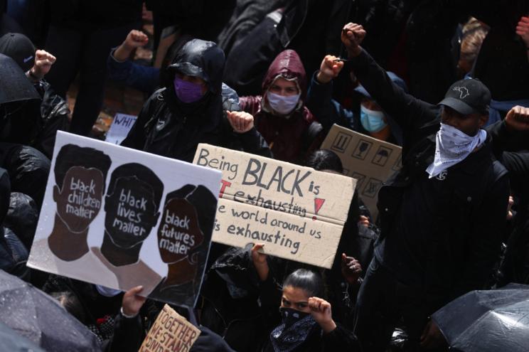 Demonstrators gesture during a protest against police brutality and the death of George Floyd, in Frankfurt, Germany.