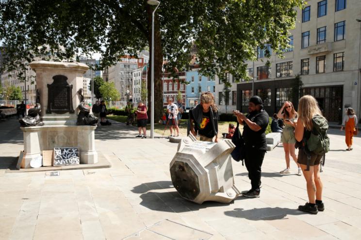 People observe the base of the statue of Edward Colston, after protesters pulled it down and pushed into the docks, following the death of George Floyd, in Bristol, Britain.