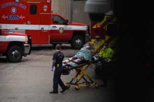 A patient is wheeled into Houston Methodist Hospital as storm clouds gather over the Texas Medical Center.